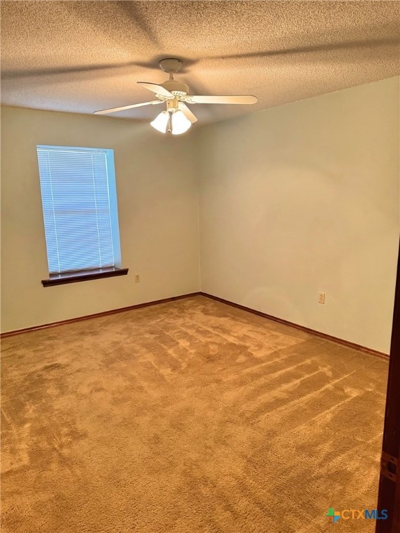 carpeted spare room featuring ceiling fan and a textured ceiling