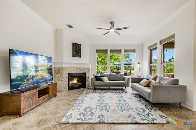 112 Oak Plaza Dr, Georgetown, TX 78628 - living area featuring ornamental molding, a ceiling fan, a tiled fireplace, and light tile patterned floors