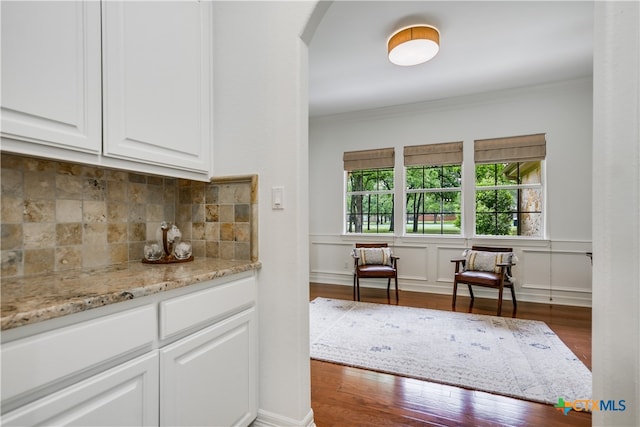 112 Oak Plaza Dr, Georgetown, TX 78628 - bar area featuring wood finished floors, arched walkways, crown molding, and decorative backsplash