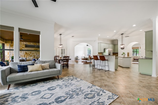112 Oak Plaza Dr, Georgetown, TX 78628 - living area featuring arched walkways, a ceiling fan, ornamental molding, recessed lighting, and light tile patterned floors