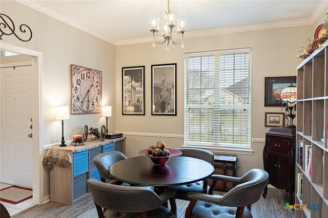 dining area with an inviting chandelier, crown molding, and light wood-type flooring