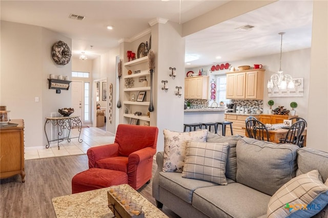 living room with a chandelier and light hardwood / wood-style floors