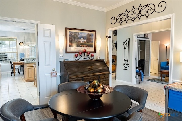 living area with light tile patterned floors, ornamental molding, and a chandelier