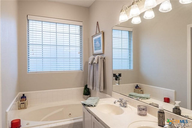 bathroom featuring vanity, tiled tub, and plenty of natural light