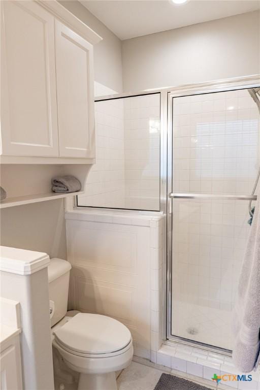 bathroom with vanity, a shower with shower door, and toilet