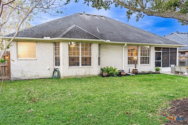 rear view of property featuring a lawn