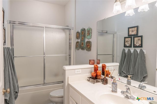 full bathroom featuring vanity, bath / shower combo with glass door, and toilet