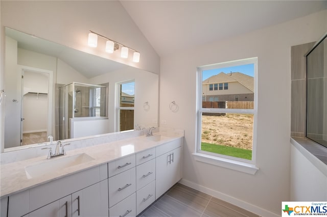 bathroom with walk in shower, vanity, and vaulted ceiling