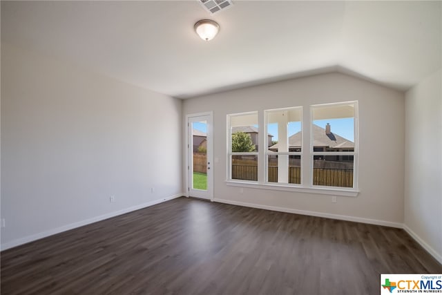 spare room with dark wood-type flooring and vaulted ceiling