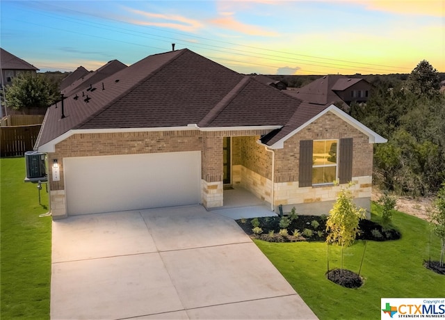 ranch-style house featuring a lawn, cooling unit, and a garage