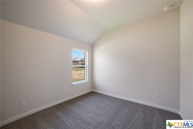 spare room with vaulted ceiling and carpet floors