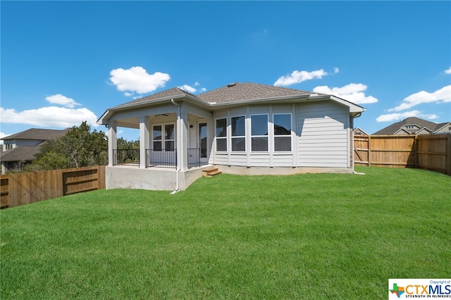 rear view of house featuring a lawn