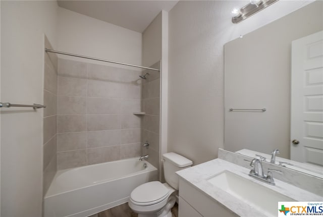 full bathroom with toilet, tiled shower / bath combo, vanity, and wood-type flooring