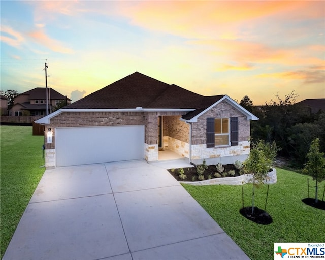 view of front of house featuring a garage and a yard