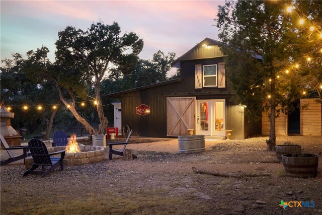 back house at dusk with an outdoor fire pit