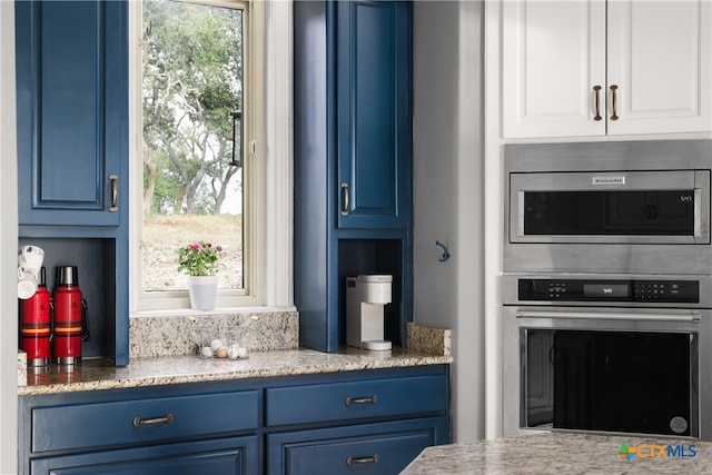 kitchen with white cabinetry, stainless steel appliances, and blue cabinets