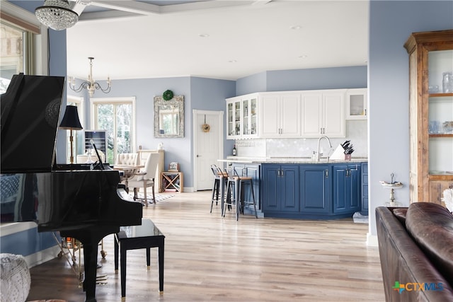 interior space featuring light wood-type flooring, sink, and an inviting chandelier