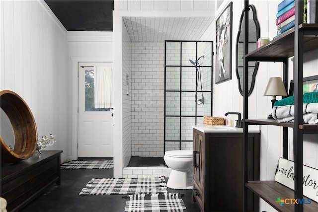 bathroom featuring concrete flooring, vanity, toilet, and a tile shower