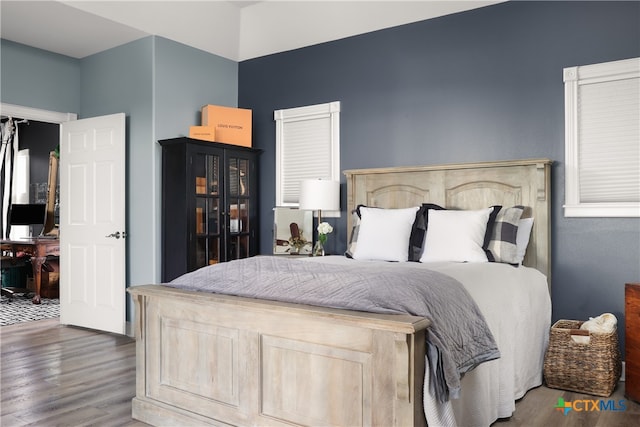 bedroom with dark hardwood / wood-style flooring