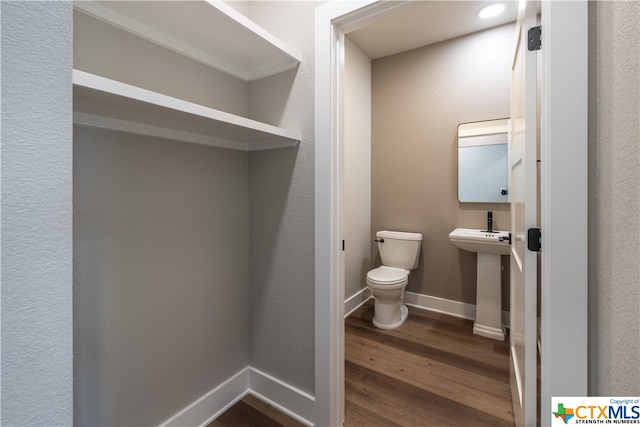 bathroom featuring hardwood / wood-style flooring, toilet, and sink