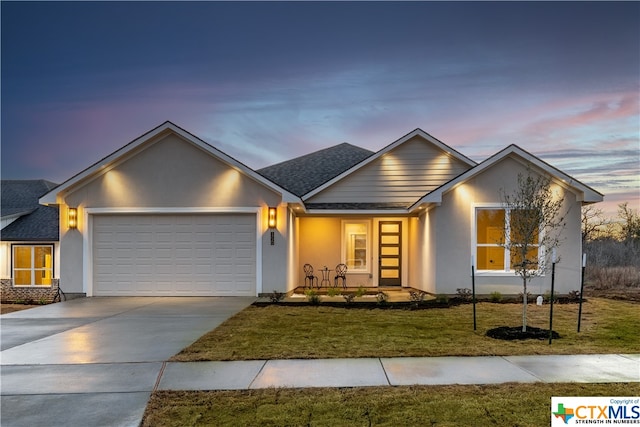 view of front of house with a garage and a yard