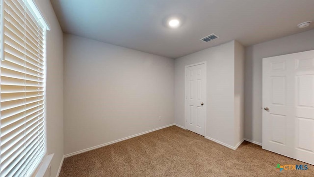 unfurnished bedroom featuring light carpet