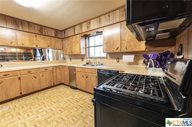 kitchen with sink, exhaust hood, and black appliances