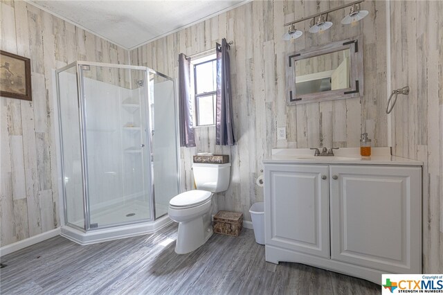 bathroom featuring toilet, an enclosed shower, crown molding, vanity, and hardwood / wood-style floors