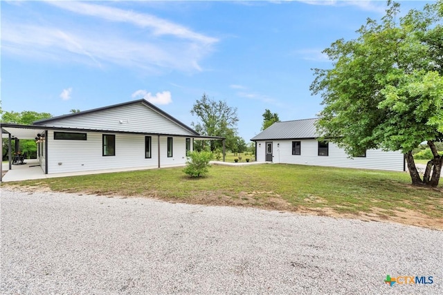 view of front of property featuring a front yard and metal roof