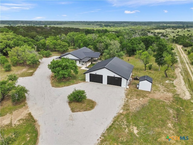 drone / aerial view featuring a wooded view