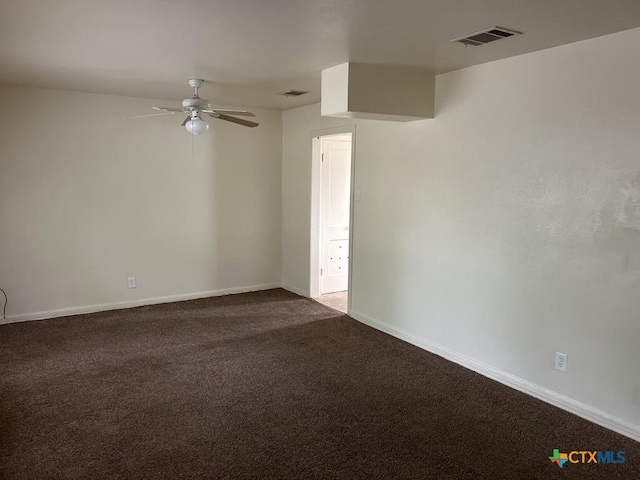 empty room featuring ceiling fan, dark colored carpet, baseboards, and visible vents