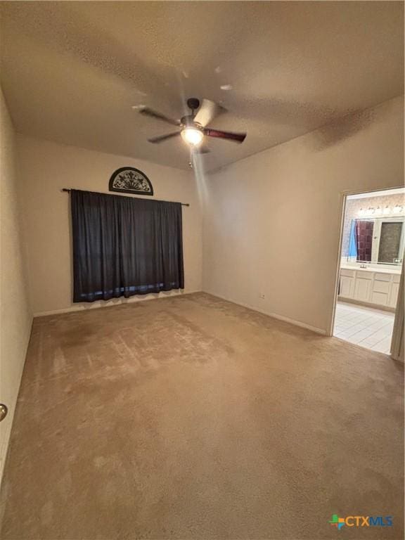 carpeted spare room featuring ceiling fan and a textured ceiling