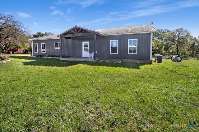 rear view of house featuring a patio area, a yard, and central AC