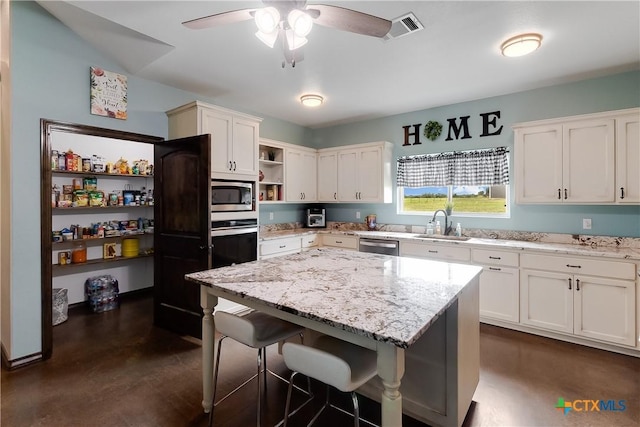 kitchen with white cabinetry, a breakfast bar, a center island, and stainless steel appliances