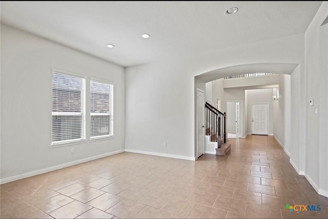 30125 Prairie Creek Ct, Brookshire, TX 77423 - spare room with arched walkways, stairway, recessed lighting, and light tile patterned floors