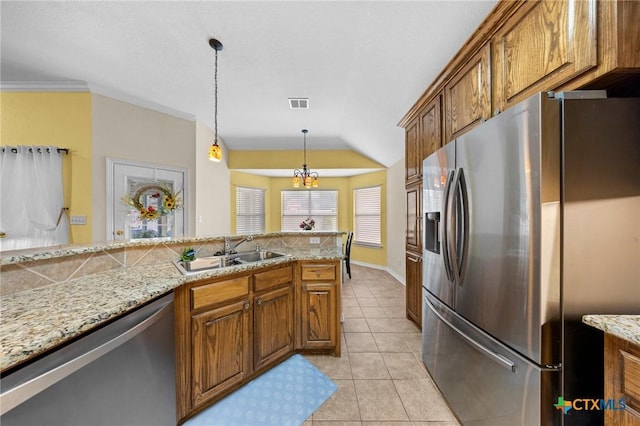 4105 Whispering Oaks, Temple, TX 76504 - kitchen with appliances with stainless steel finishes, brown cabinetry, light tile patterned floors, pendant lighting, and lofted ceiling