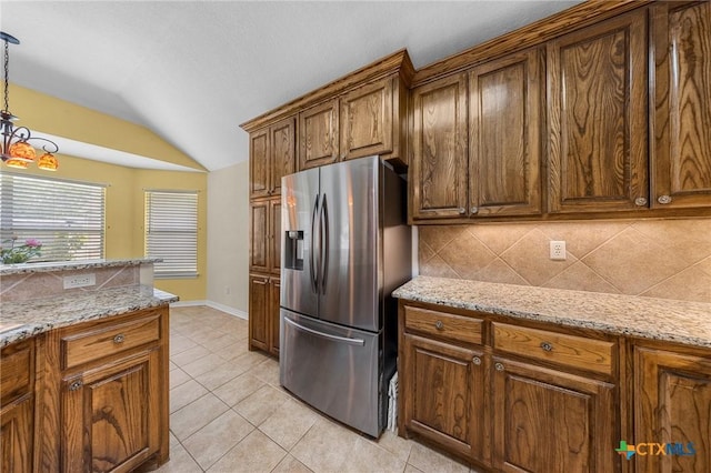 4105 Whispering Oaks, Temple, TX 76504 - kitchen featuring stainless steel refrigerator with ice dispenser, vaulted ceiling, decorative backsplash, light tile patterned flooring, and hanging light fixtures