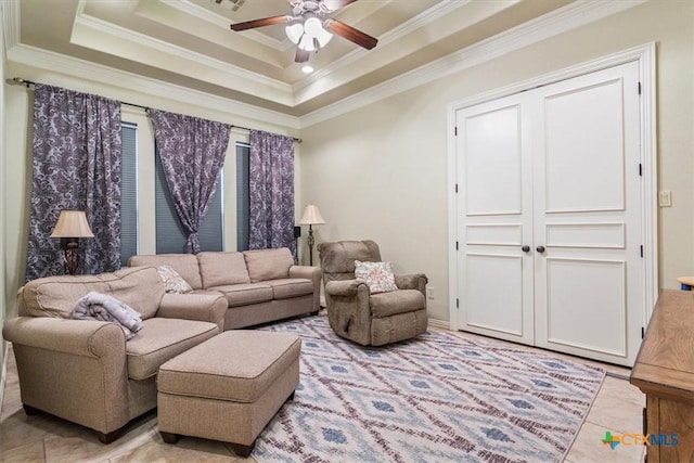 living room with light tile patterned floors, a raised ceiling, ceiling fan, and crown molding