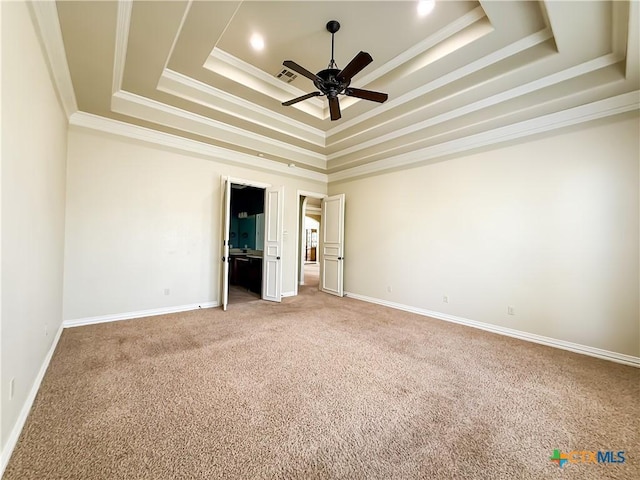 unfurnished bedroom featuring light carpet, baseboards, a tray ceiling, and ornamental molding