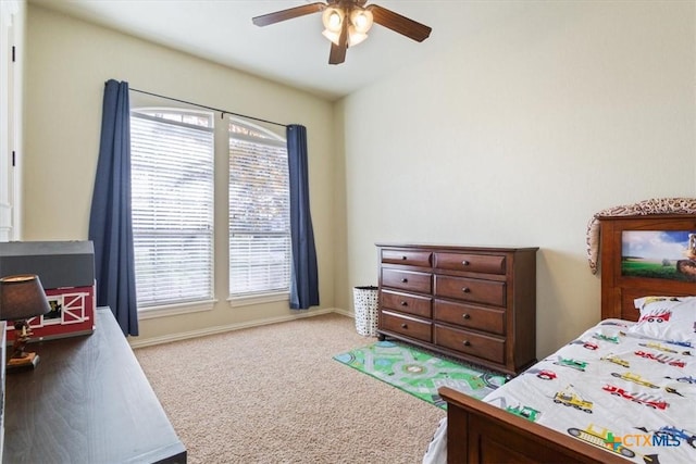 carpeted bedroom with multiple windows, baseboards, and a ceiling fan