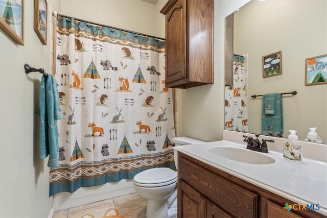 bathroom featuring toilet, shower / tub combo, vanity, and tile patterned floors