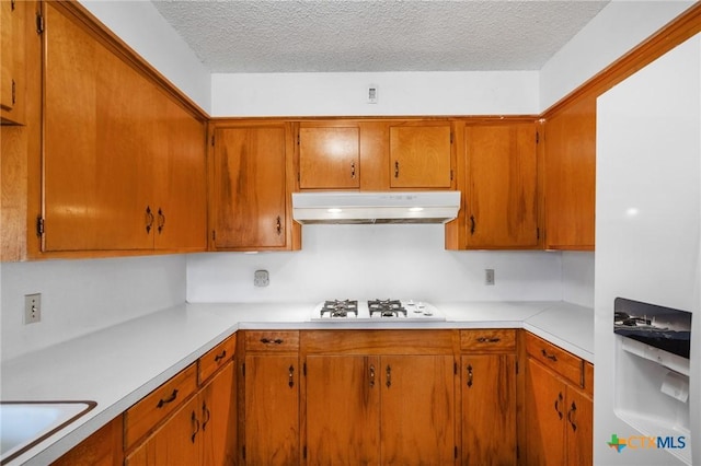 kitchen featuring sink, a textured ceiling, and white gas cooktop