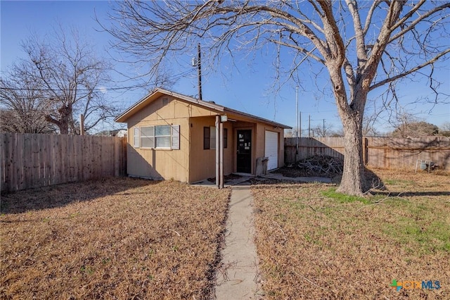 ranch-style house featuring a garage and a front lawn