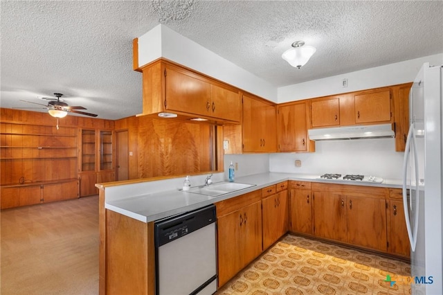 kitchen with sink, a textured ceiling, dishwasher, and white refrigerator