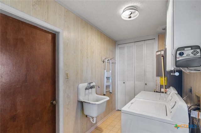 clothes washing area featuring separate washer and dryer, sink, and gas water heater