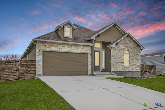 view of front of house featuring a garage and a lawn