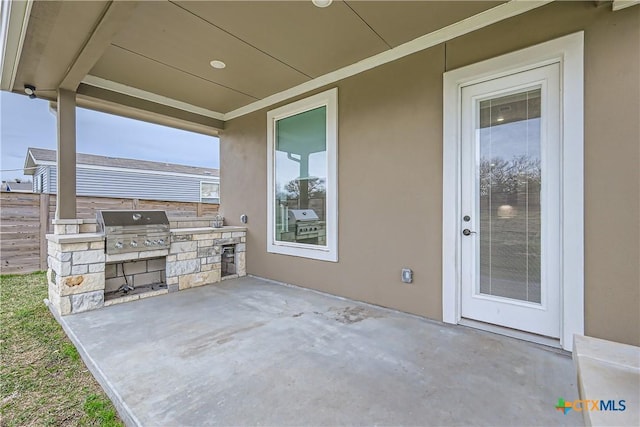 view of patio with exterior kitchen and a grill