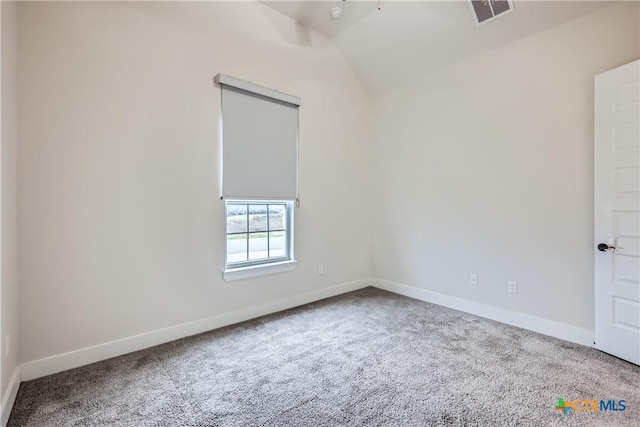 carpeted empty room with vaulted ceiling