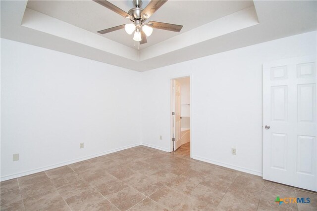 5111 Warwicke Dr, Temple, TX 76502 - empty room featuring a tray ceiling, a ceiling fan, and baseboards