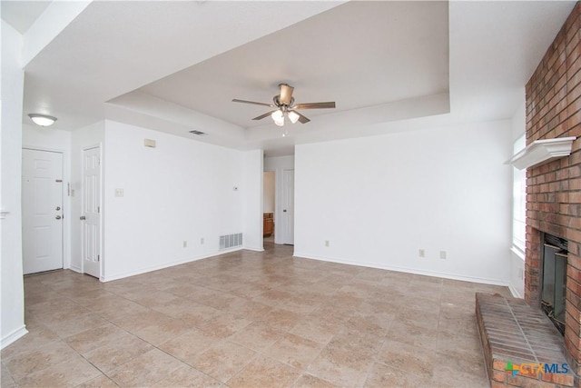 5111 Warwicke Dr, Temple, TX 76502 - unfurnished living room featuring a tray ceiling, a fireplace, ceiling fan, and baseboards
